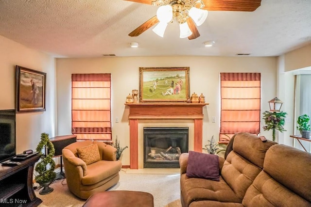 2500 Marlborough Dr, Uniontown, OH 44685 - carpeted living area with visible vents, a glass covered fireplace, ceiling fan, and a textured ceiling