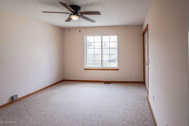 2500 Marlborough Dr, Uniontown, OH 44685 - empty room featuring baseboards, a textured ceiling, and light carpet