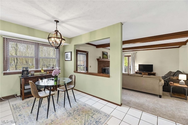 21242 Jonathan Dr, Strongsville, OH 44149 - dining space featuring light tile patterned flooring, a brick fireplace, beam ceiling, and a chandelier
