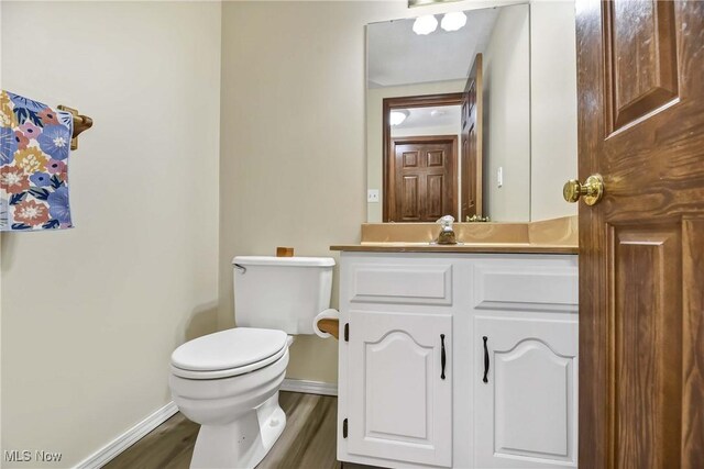 21242 Jonathan Dr, Strongsville, OH 44149 - half bath featuring toilet, vanity, baseboards, and wood finished floors