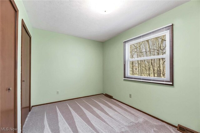 21242 Jonathan Dr, Strongsville, OH 44149 - unfurnished bedroom with carpet flooring, baseboards, a textured ceiling, visible vents, and a closet