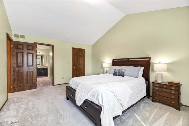 21242 Jonathan Dr, Strongsville, OH 44149 - bedroom with light carpet, visible vents, ensuite bathroom, and vaulted ceiling
