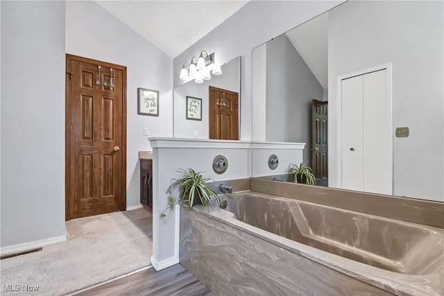 21242 Jonathan Dr, Strongsville, OH 44149 - full bath with vanity, lofted ceiling, baseboards, visible vents, and a bath