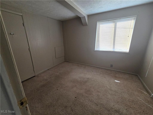 unfurnished bedroom with baseboards, carpet, and a textured ceiling
