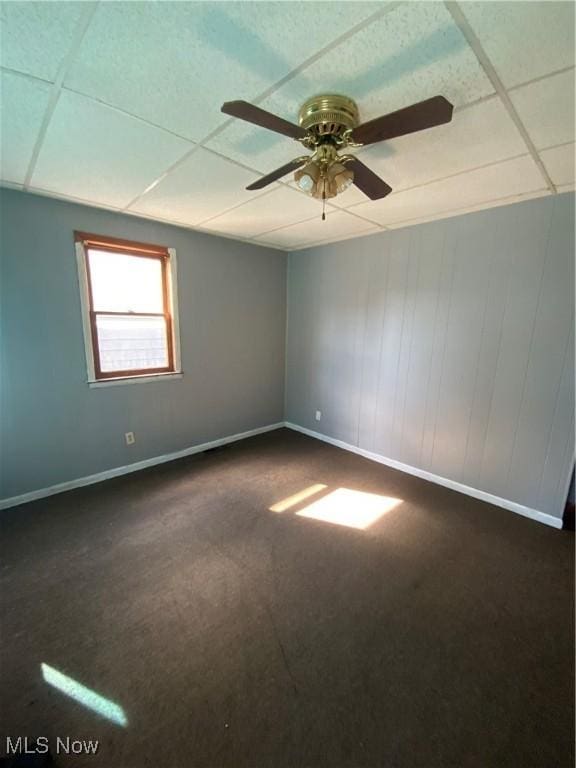 515 E Sixth St, East Liverpool, OH 43920 - spare room with baseboards, dark carpet, ceiling fan, and a paneled ceiling
