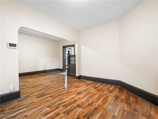 empty room featuring baseboards and wood finished floors
