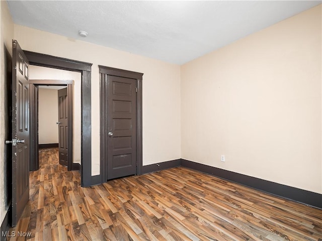 unfurnished bedroom with baseboards and wood finished floors