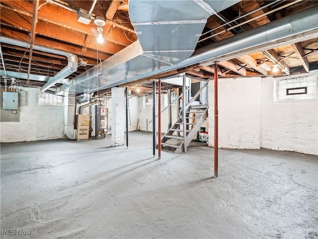 below grade area with stairs, heating unit, gas water heater, and electric panel