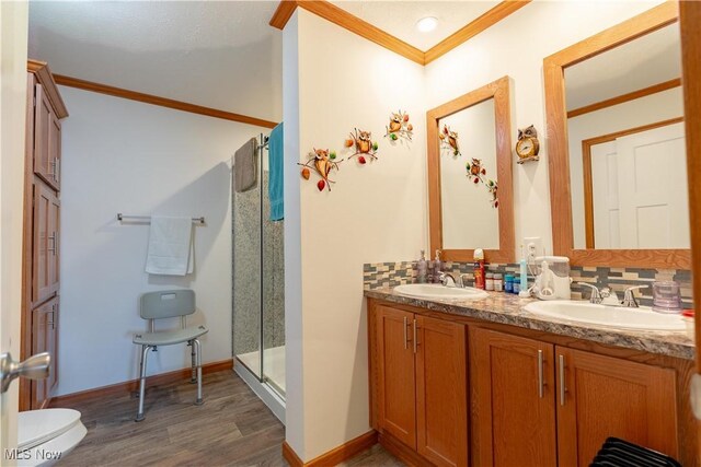 2409 Chelsea Dr SW, Canton, OH 44706 - bathroom with wood finished floors, a sink, ornamental molding, and a shower stall