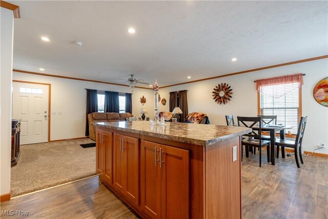 2409 Chelsea Dr SW, Canton, OH 44706 - kitchen featuring plenty of natural light, brown cabinets, wood finished floors, and a kitchen island
