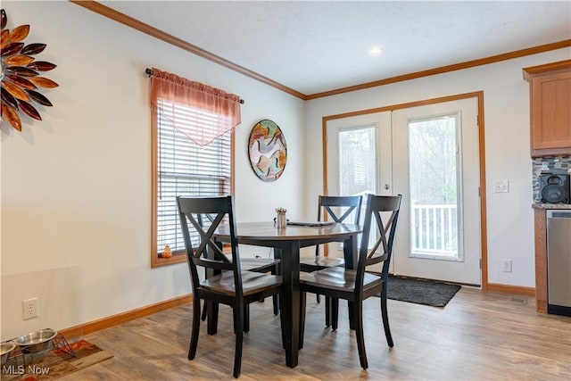 2409 Chelsea Dr SW, Canton, OH 44706 - dining room with light wood finished floors, baseboards, crown molding, and french doors