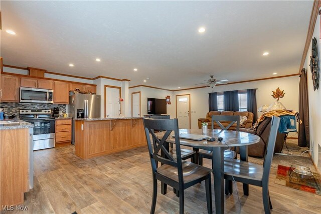 2409 Chelsea Dr SW, Canton, OH 44706 - dining area featuring light wood-type flooring, crown molding, recessed lighting, and a ceiling fan