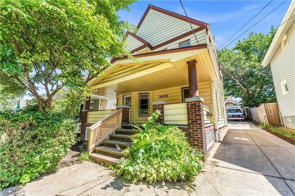 view of front of home featuring covered porch and fence