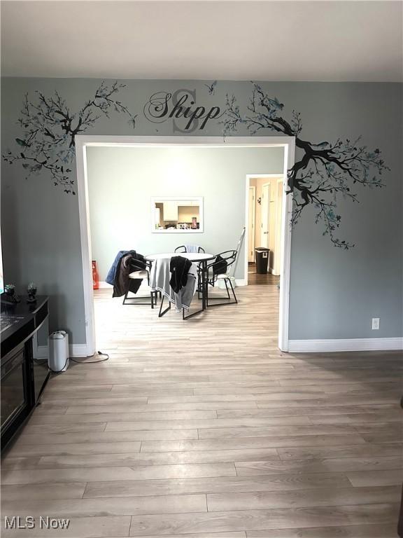 dining area featuring light wood finished floors and baseboards