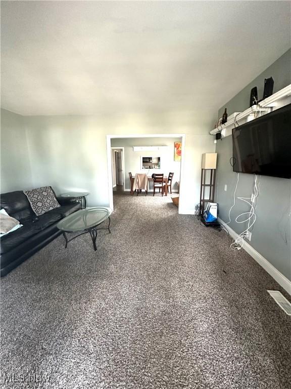 unfurnished living room featuring baseboards and visible vents