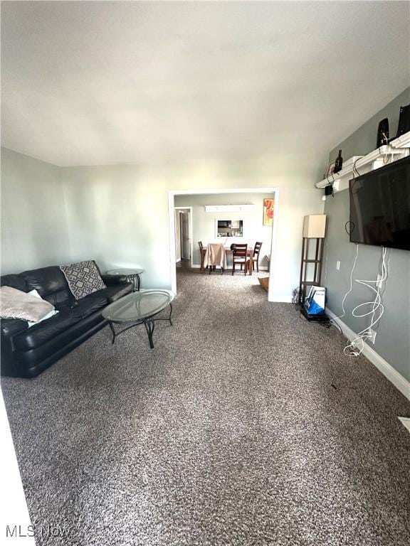 carpeted living area featuring baseboards