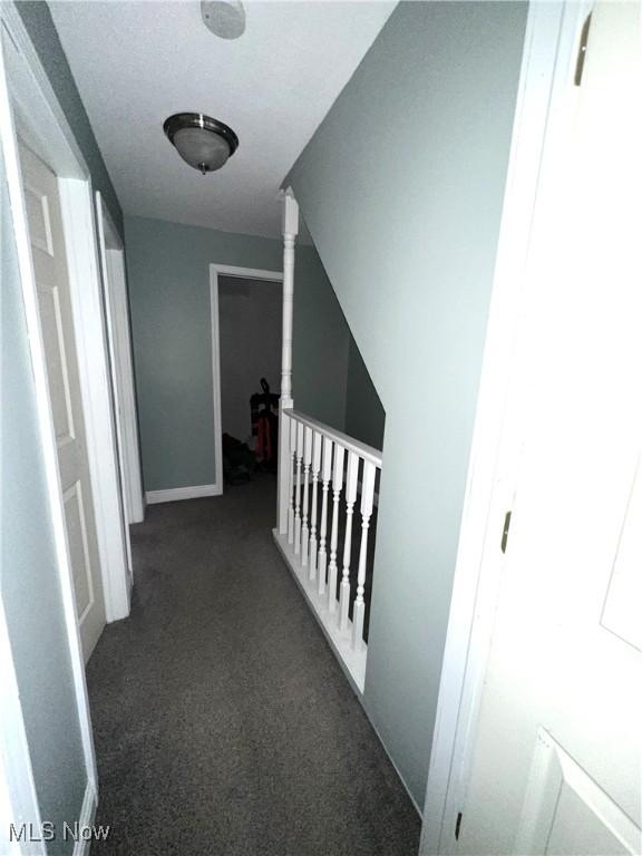 corridor with carpet flooring and an upstairs landing