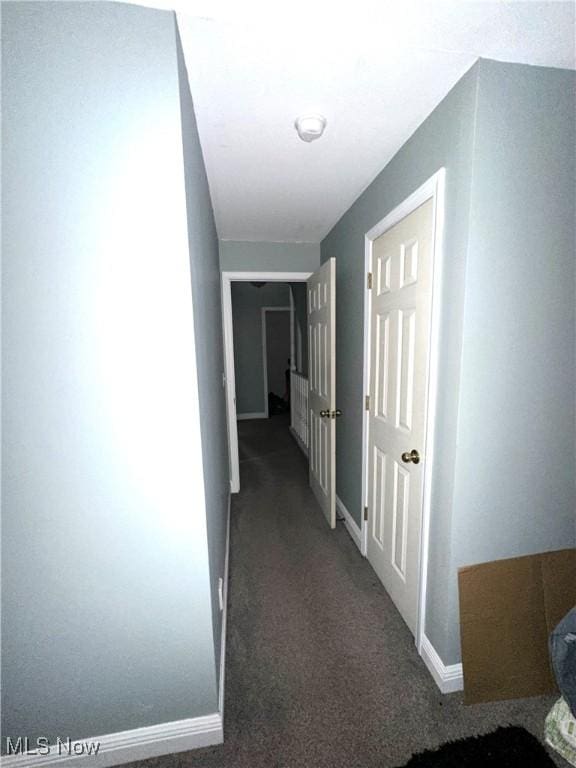 corridor with carpet flooring and baseboards