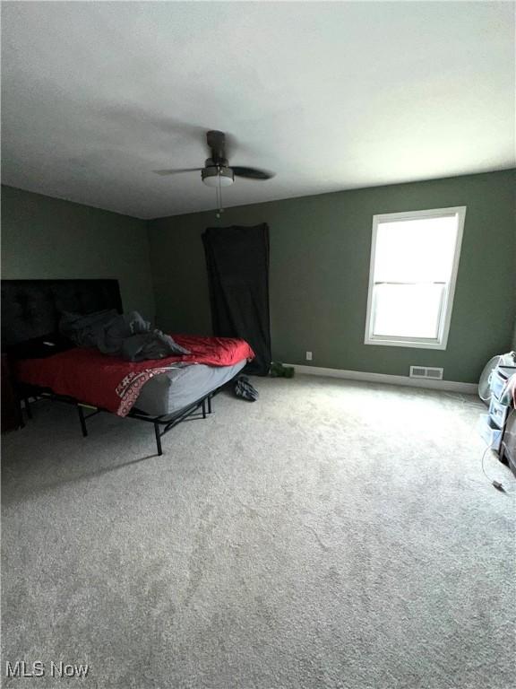 bedroom featuring baseboards, carpet floors, ceiling fan, and visible vents
