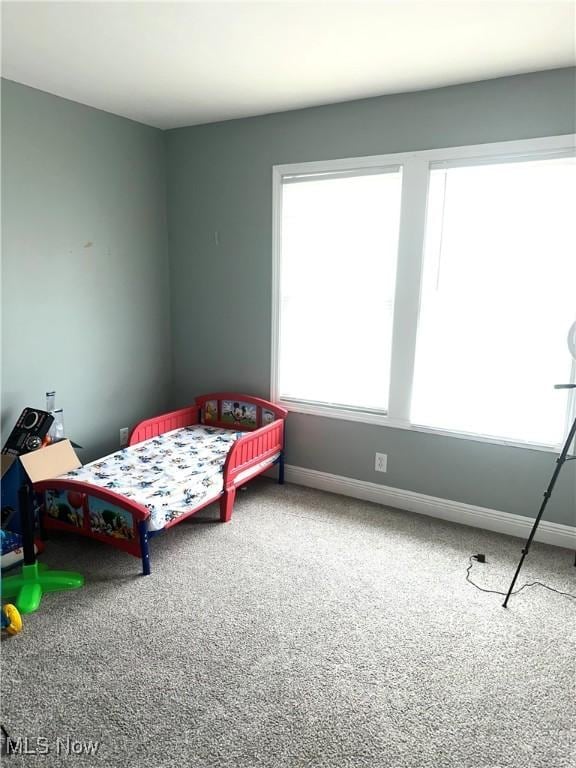 carpeted bedroom featuring baseboards