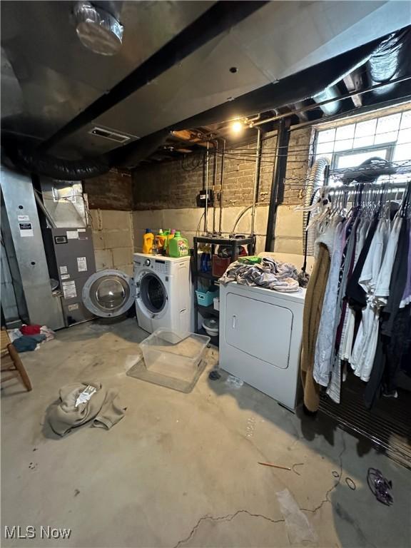 unfinished basement with washing machine and dryer and heating unit