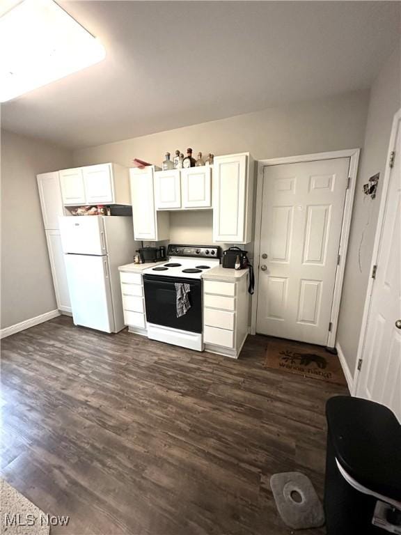 kitchen with white cabinetry, freestanding refrigerator, dark wood-style flooring, and electric range oven