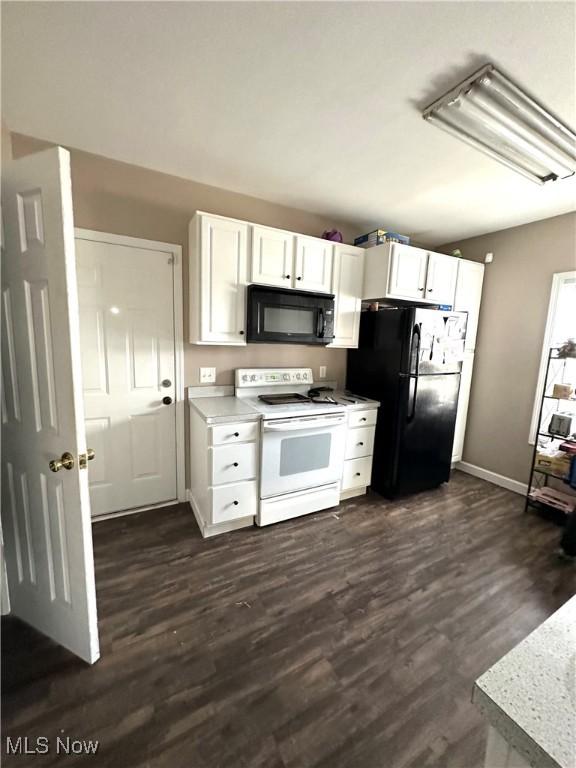 kitchen featuring light countertops, white cabinets, dark wood-style floors, and black appliances