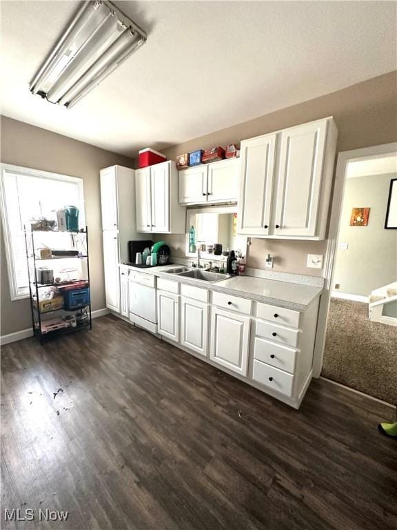 kitchen featuring dark wood finished floors, white cabinetry, light countertops, and a sink