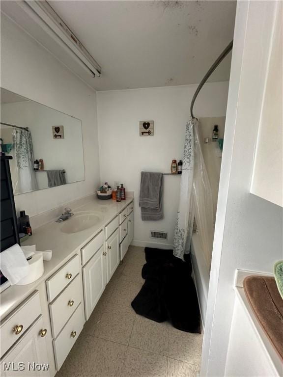bathroom featuring curtained shower, visible vents, tile patterned floors, and vanity