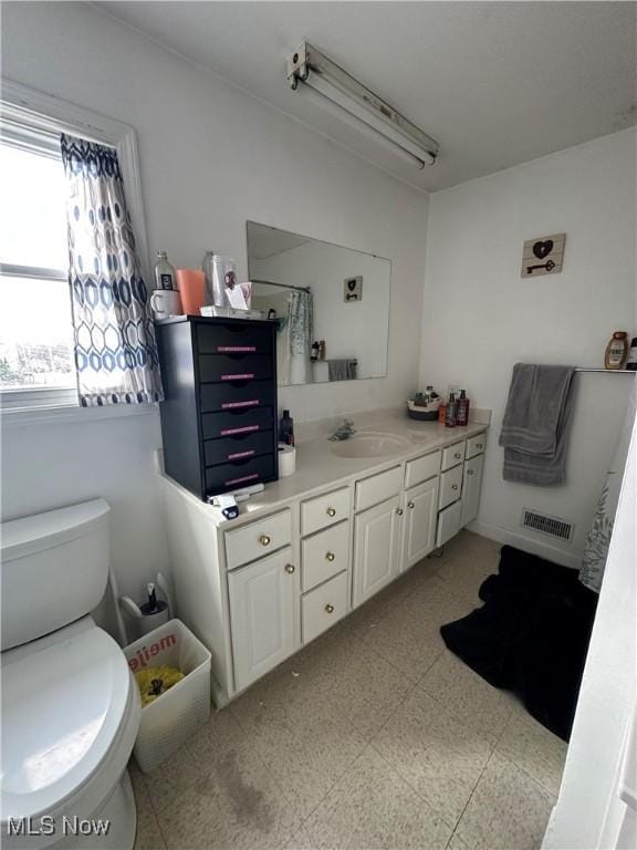 bathroom with tile patterned floors, toilet, a shower, vanity, and visible vents