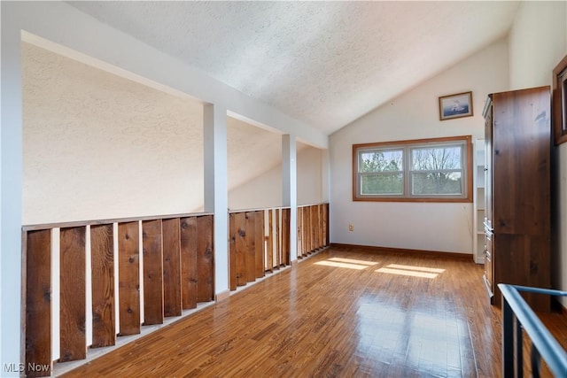 3871 Foskett Rd, Medina, OH 44256 - unfurnished room featuring wood-type flooring, baseboards, vaulted ceiling, and a textured ceiling