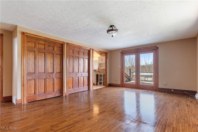 3871 Foskett Rd, Medina, OH 44256 - unfurnished bedroom featuring two closets, baseboards, wood finished floors, access to exterior, and french doors