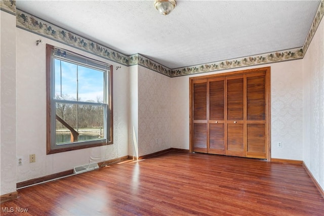3871 Foskett Rd, Medina, OH 44256 - unfurnished bedroom with baseboards, visible vents, wood finished floors, and a textured ceiling