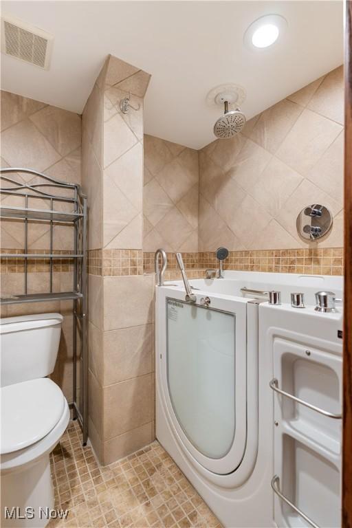 3871 Foskett Rd, Medina, OH 44256 - bathroom with tile walls, toilet, tiled shower, visible vents, and recessed lighting