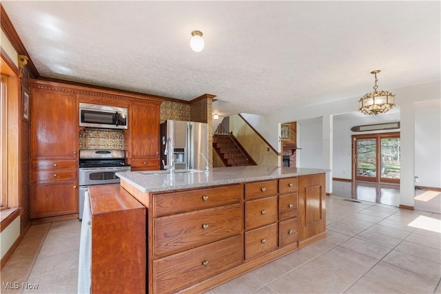 3871 Foskett Rd, Medina, OH 44256 - kitchen with a center island with sink, light tile patterned floors, stainless steel appliances, and brown cabinetry