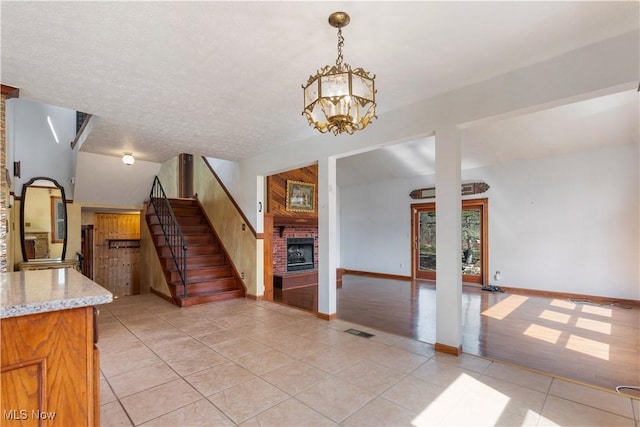 3871 Foskett Rd, Medina, OH 44256 - interior space with a chandelier, a fireplace, a textured ceiling, light tile patterned floors, and visible vents