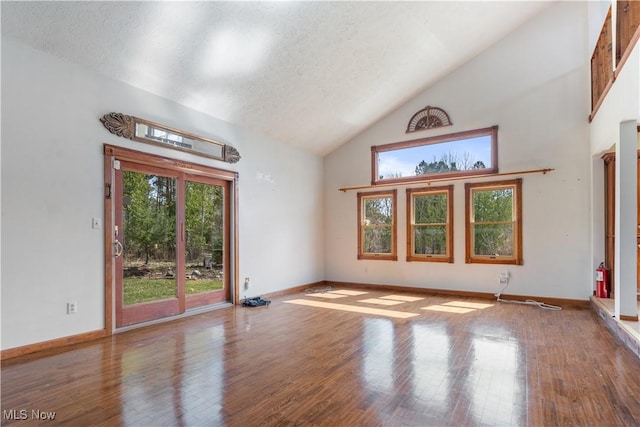 3871 Foskett Rd, Medina, OH 44256 - empty room with baseboards, a textured ceiling, high vaulted ceiling, and wood finished floors