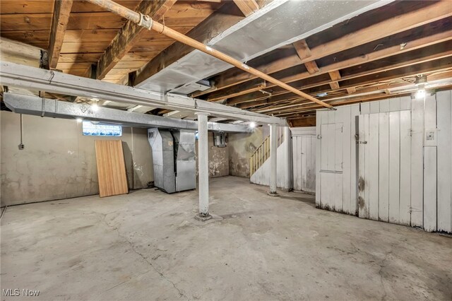 basement with heating unit and stairs
