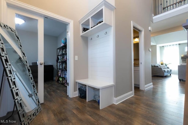mudroom featuring dark wood-style flooring and baseboards