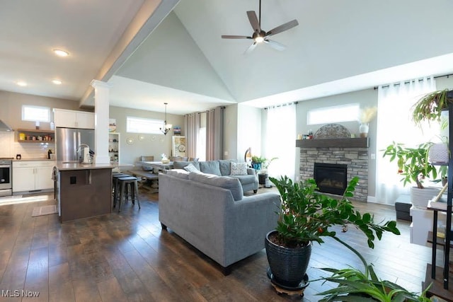 living room with dark wood finished floors, ceiling fan, a fireplace, and high vaulted ceiling
