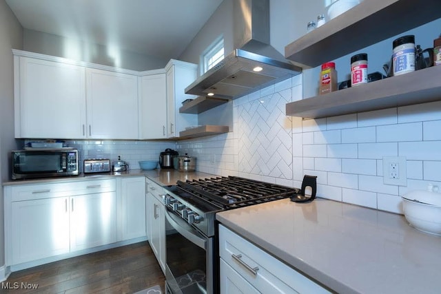 kitchen with island range hood, gas range, open shelves, white cabinets, and decorative backsplash