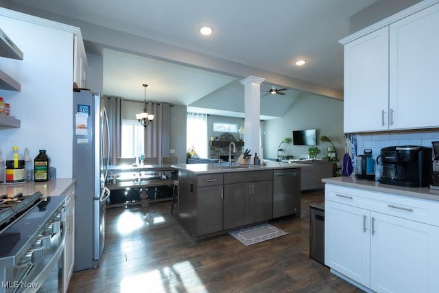 kitchen featuring appliances with stainless steel finishes, a sink, open floor plan, white cabinetry, and dark wood finished floors