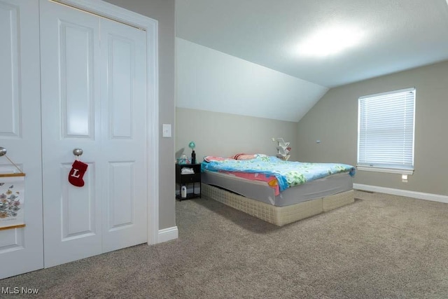 bedroom with carpet, baseboards, and lofted ceiling