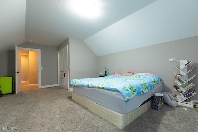 carpeted bedroom featuring lofted ceiling and baseboards