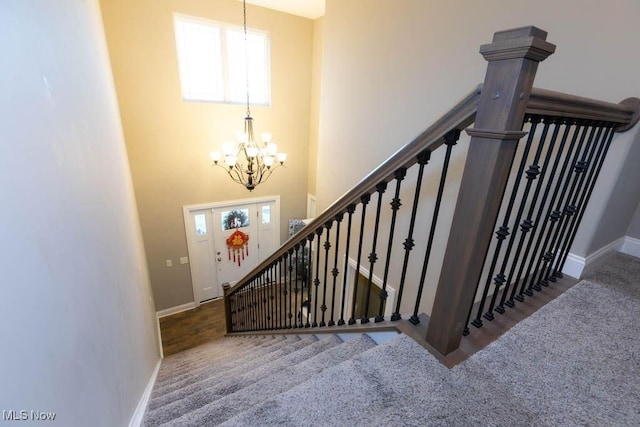 staircase with a chandelier and baseboards