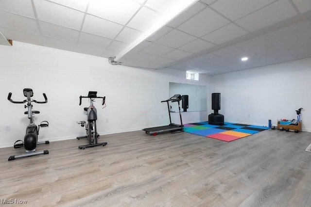 exercise area with wood finished floors, a drop ceiling, baseboards, and recessed lighting