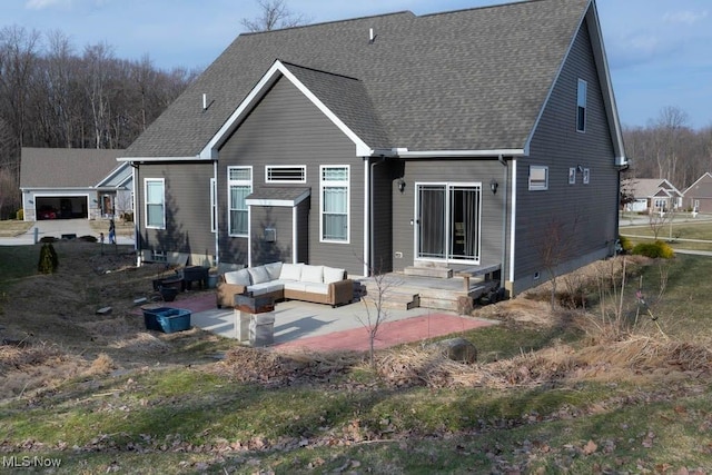 back of property with a patio area, roof with shingles, and outdoor lounge area