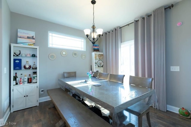 dining space with a chandelier, dark wood-style flooring, and baseboards