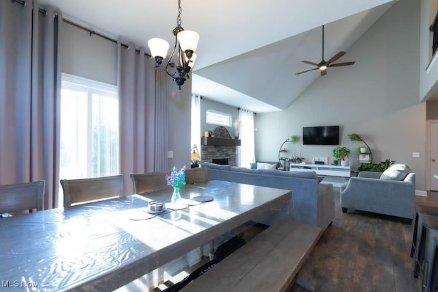 dining space with a fireplace, a chandelier, ceiling fan, wood finished floors, and high vaulted ceiling