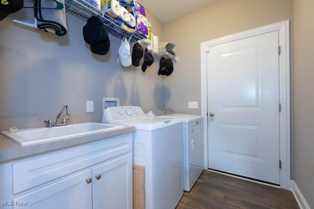 laundry area featuring washer and clothes dryer, wood finished floors, and cabinet space